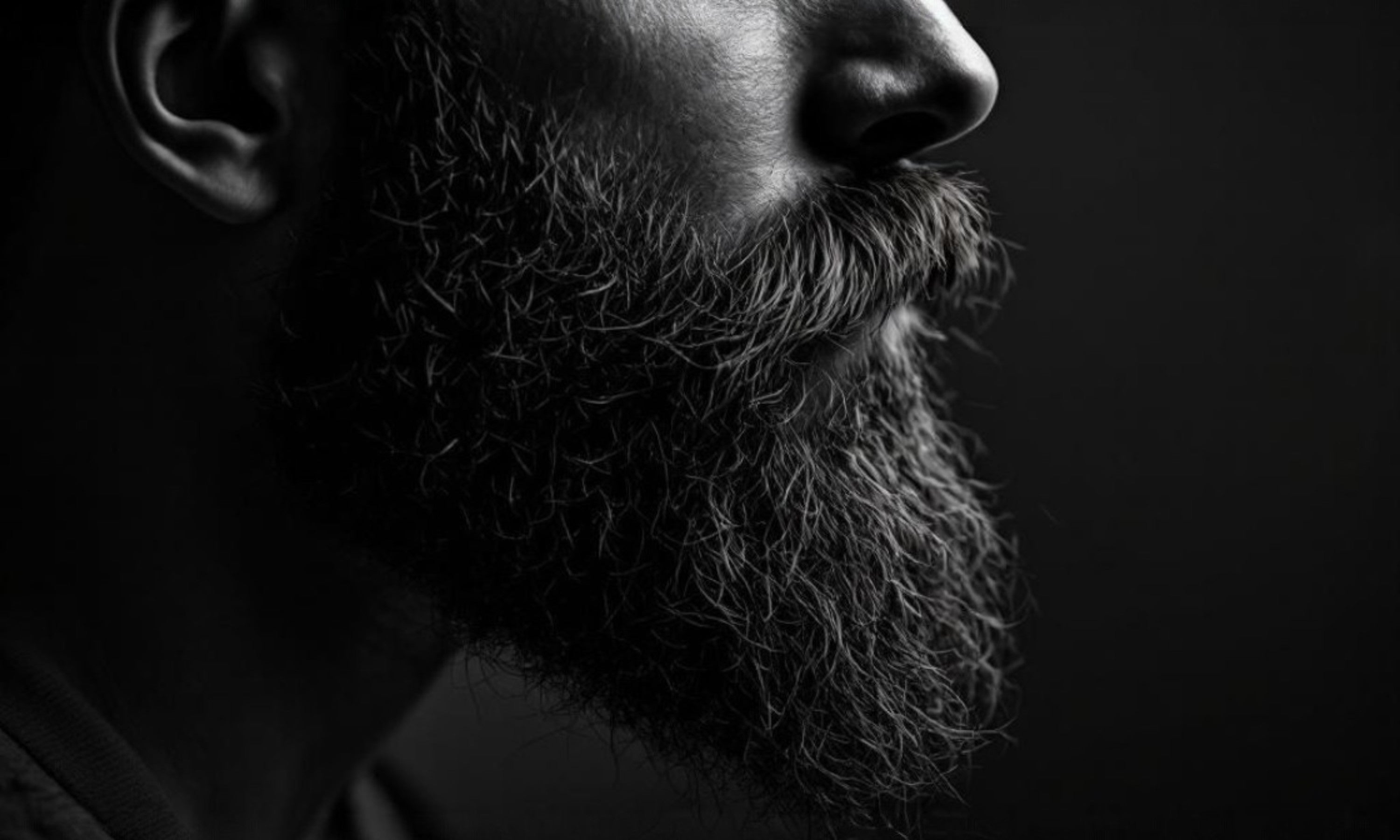 Close-up of a person with a beard against a dark background