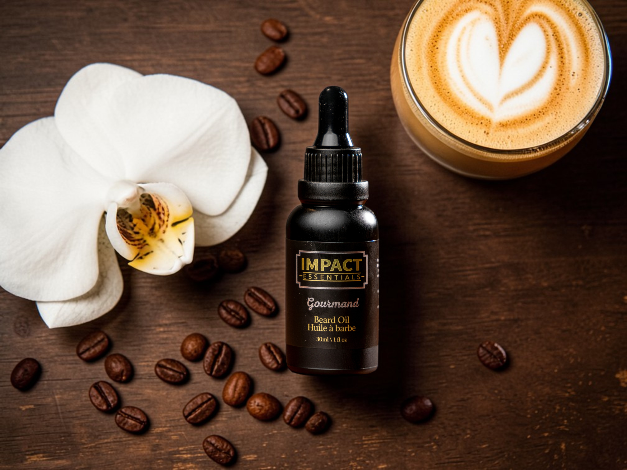Bottle of Impact Gourmet beard oil on a wooden surface with coffee beans, a white orchid, and a cappuccino.